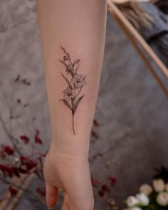 a woman's arm with a flower tattoo on it