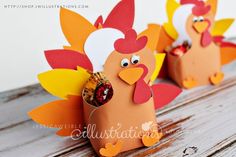 three paper turkeys sitting on top of a wooden table