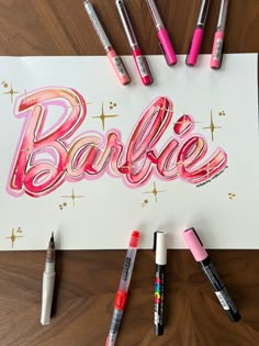 the word barbie is surrounded by markers and crayons on a piece of paper