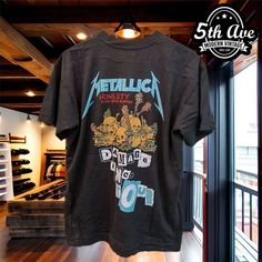 a t - shirt with metallichead on it hanging in front of a store window