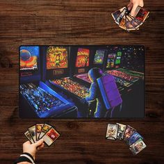 a person playing an arcade game on a wooden table