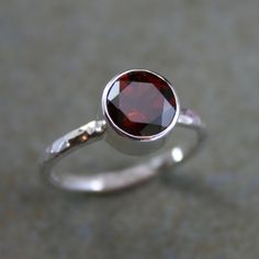 Deep red garnet faceted to catch the light. Set in solid sterling silver and polished to a bright shine. I've given the sterling silver band a lightly hammered texture and a bright polish to compliment the faceted stone. 8mm garnet gemstone. This ring will be made to order in your size. Please select your size from the drop down menu when you check out. For more options: https://www.etsy.com/shop/KiraFerrer?ref=shopsection_leftnav_1&search_query=Solitaire+Statement+Ring To see my entire coll Garnet Stone Ring, Sterling Silver Garnet Ring, Antique Jewellery Designs, Green Amethyst Ring, Red Jewel, Hammered Band, Gold Rings Fashion, Jewels Rings, Sterling Silver Rings Bands