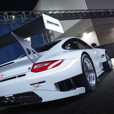 a white sports car parked in front of a building