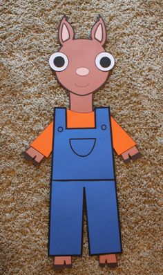 a paper cut out of an animal wearing overalls