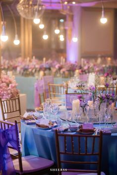 the tables are set with purple and blue linens