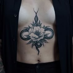 a woman with a snake and rose tattoo on her stomach