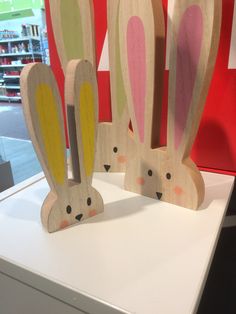 two wooden rabbits sitting on top of a white counter