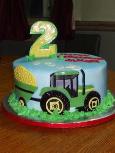 a two year old birthday cake with a tractor on the front and number 2 on the back