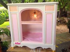 an old fashioned pink and white cabinet with chandelier