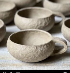 several clay cups sitting on top of a table