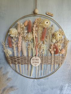 a bunch of dried flowers sitting on top of a metal rack in front of a wall