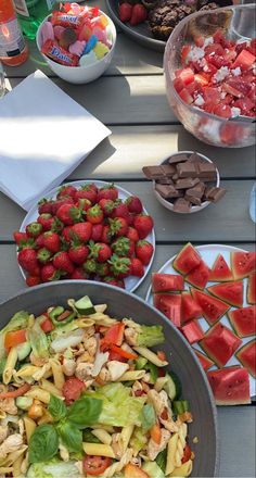 a table topped with plates of food and bowls of strawberries next to each other