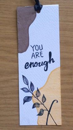 a piece of paper that says you are enough on it with a plant in the middle