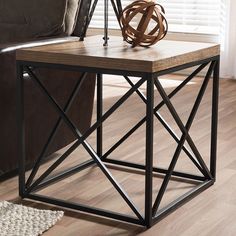 an end table with a lamp on it in front of a brown leather couch and window