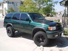 a green truck parked in front of a house