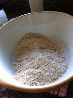 a white bowl filled with flour sitting on top of a counter