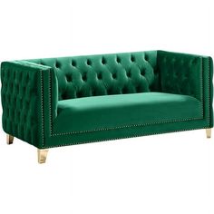 a green velvet couch with gold legs and studded trimmings on the arms