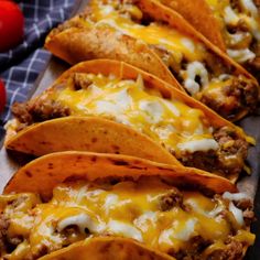 several tacos are lined up on a cutting board