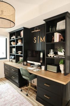 a home office with black bookcases and wooden floors