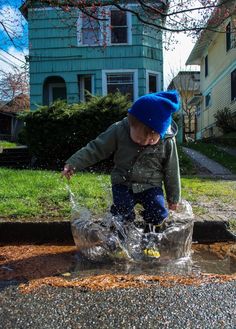 a young boy splashing water from a bucket