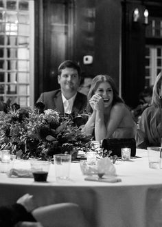 a group of people sitting at a table with food and drinks in front of them