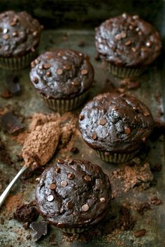 chocolate muffins on a baking sheet with a spoon