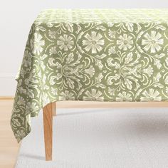 a green and white table cloth on top of a wooden chair in front of a wall