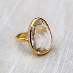 D E T A I L S - Material: 92.5 sterling silverStone: CrystalThe fit: true to US ring size Finish: smooth and Gold Plated to a high shineS H I P P I N G & P R O D U C T I O N - My current production time is 2-6 business days, which means after those days are up, your order ships! I make everything custom to order, by hand, but I promise you it's worth the wait!R U S H - M Y - O R D E R -If you're in a rush to get your pretty new pieces, please send me a message and I'll let you know just how Classic Large Stone Promise Ring, Fine Jewelry Crystal Ring With Large Stone For Promise, Open Crystal Ring With Large Stone For Weddings, Fine Jewelry Crystal Ring With Large Stone, Fine Jewelry Crystal Promise Ring With Large Stone, Classic Faceted Crystal Ring For Anniversary, Gold Sterling Silver Rings With Large Stone, Wedding Crystal Ring With Large Stone, Open Design, Wedding Crystal Ring With Large Stone