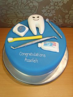 a blue cake with toothbrushes, dental floss and other items on it