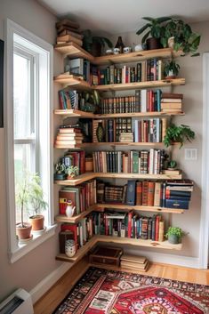 a bookshelf filled with lots of books in front of a window next to a rug