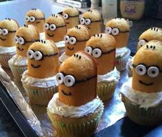 minion cupcakes with white frosting and googly eyes sitting on top of each other