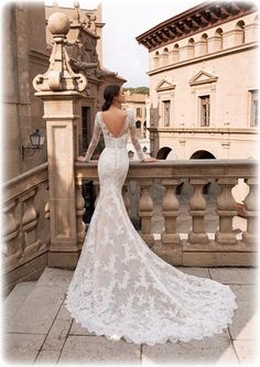 a woman in a wedding dress standing on a balcony