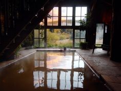 an indoor swimming pool in the middle of a room with stairs leading up to it