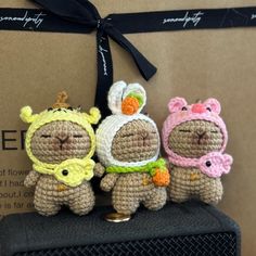 three small crocheted animals sitting next to each other on top of a box