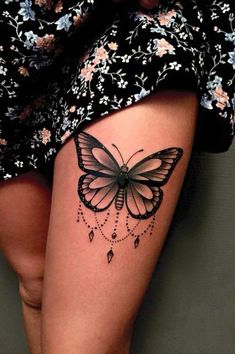 a woman's thigh with a butterfly tattoo on the side of her leg,