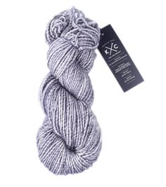 a skein of yarn on a white background with a tag for the knitting project