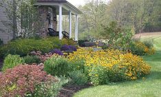 a house with lots of flowers in the front yard