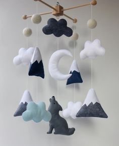 a mobile made to look like mountains, clouds and a bear is hanging from the ceiling