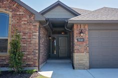 a brick house with two garages in the front and one door on the side