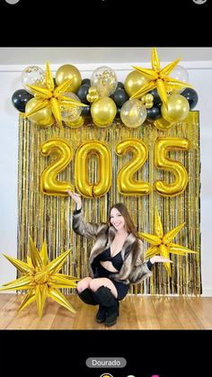 a woman sitting on the floor in front of balloons and streamers that say 205