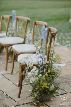 the chairs are lined up with flowers on them