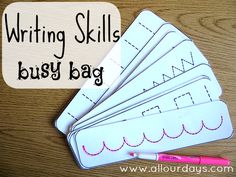 four writing skills for busy bags on a wooden table with pink pen and paper clippings