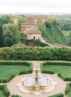 a garden with a fountain surrounded by hedges