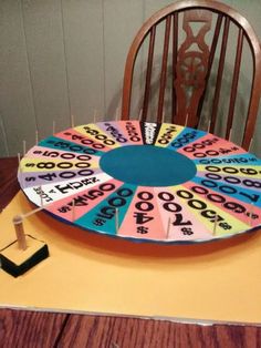 a wheel of fortune sitting on top of a table next to a pair of scissors