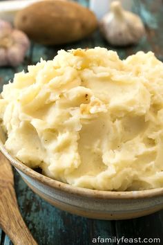 a bowl filled with mashed potatoes on top of a wooden table