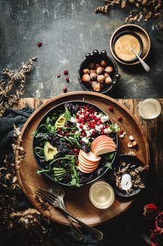 an overhead view of a salad with apples, avocado and cranberries