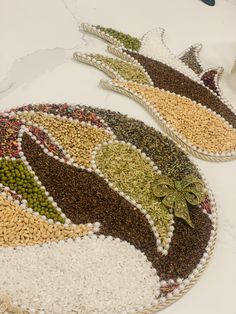 two baskets filled with beans and peas on top of a white tablecloth covered floor