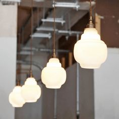 five white lights hanging from the ceiling in a room