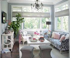 a living room filled with furniture and a chandelier hanging from the skylight