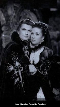 an old black and white photo of two people dressed in medieval clothing, one holding the other